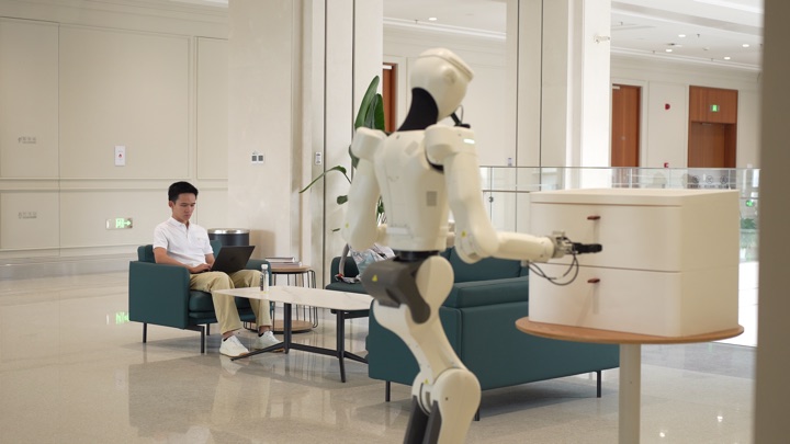 The robot navigates and manipulates in sequence to retrieve and deliver a power bank, frame 2 of 3.
