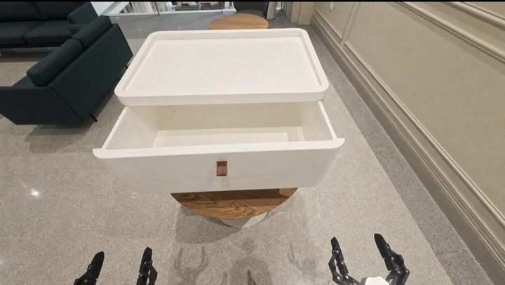 The robot searches cabinet drawers for a power bank absent from the scene graph, frame 1 of 3.